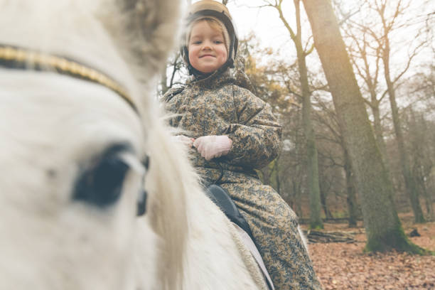 widok dziecka siedzącego na koniu